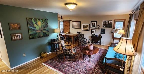 sitting room with plenty of natural light, baseboards, and wood finished floors