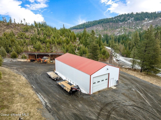 drone / aerial view featuring a mountain view and a forest view