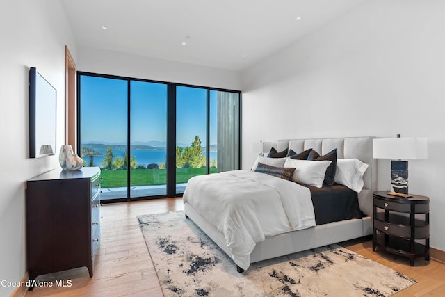 bedroom featuring access to exterior, recessed lighting, a mountain view, light wood-type flooring, and baseboards