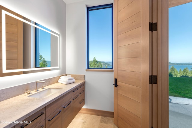 bathroom with a water view, vanity, and baseboards