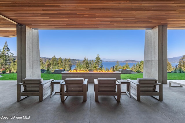 view of patio with an outdoor living space with a fire pit and a water and mountain view