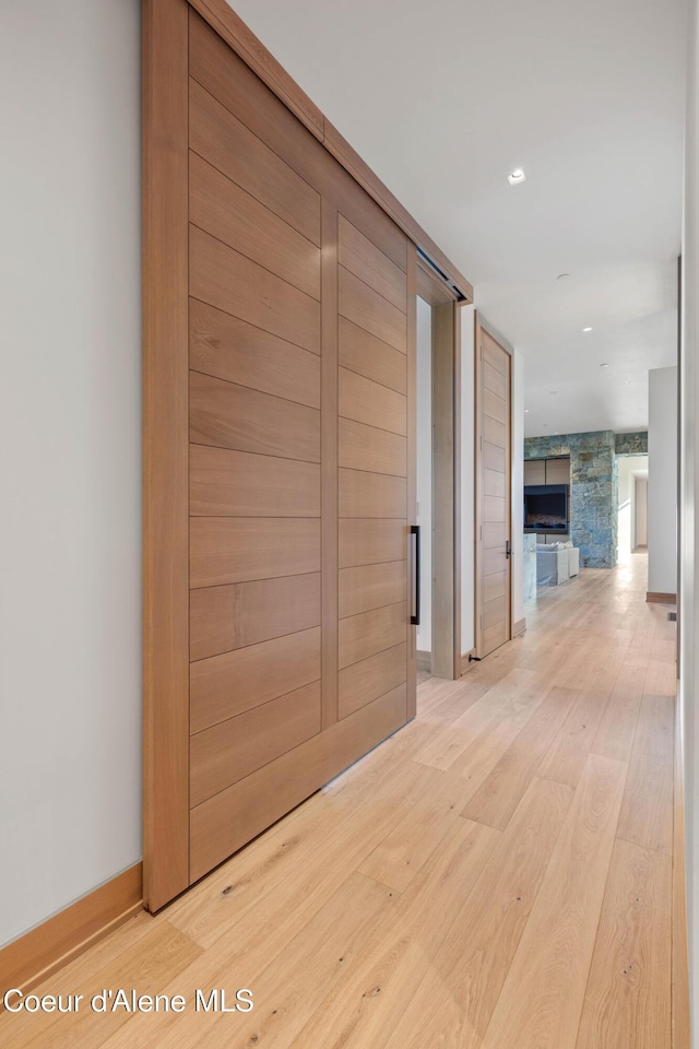 hall with baseboards and wood finished floors