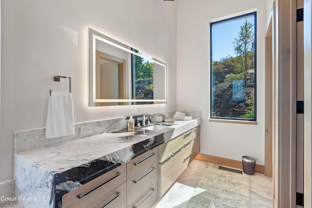 bathroom with marble finish floor, baseboards, and vanity