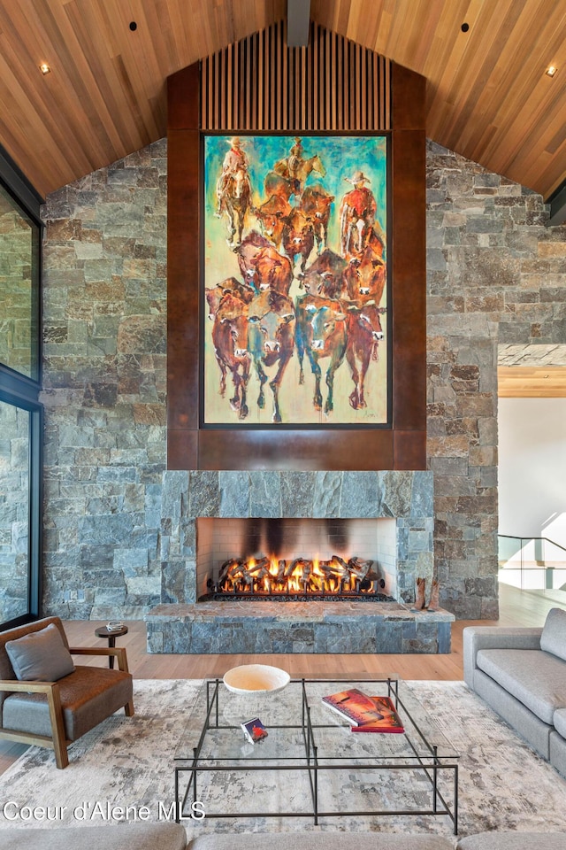 living area with high vaulted ceiling, wooden ceiling, wood finished floors, and a high end fireplace