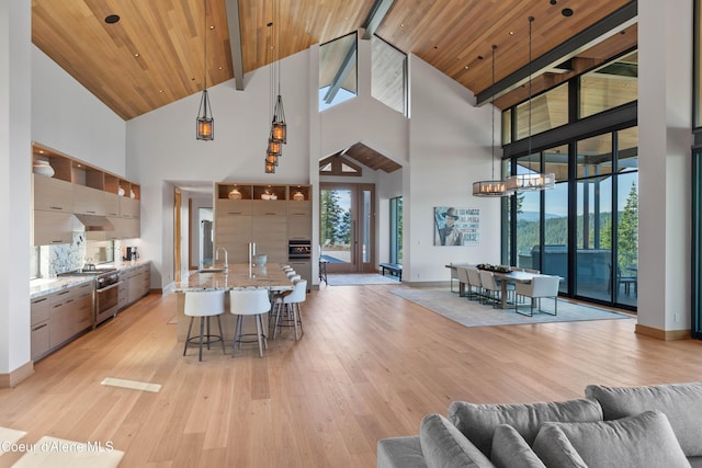 dining room featuring wooden ceiling, baseboards, a wealth of natural light, and light wood-style floors