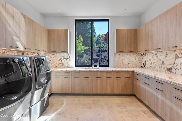 clothes washing area featuring cabinet space, a sink, and separate washer and dryer