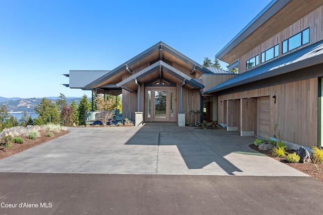 view of exterior entry featuring a garage, a mountain view, and concrete driveway