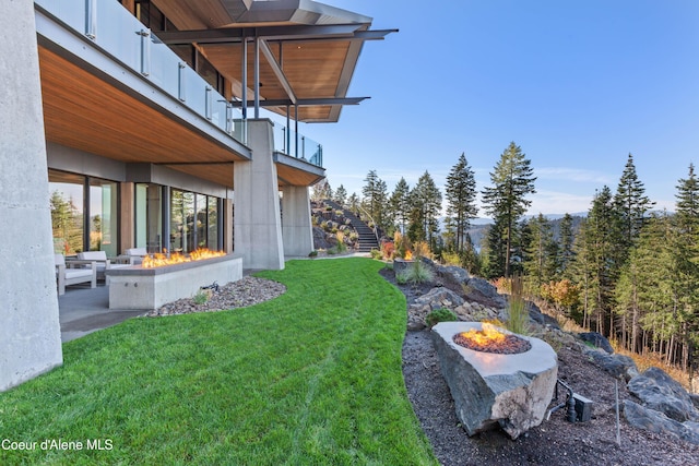 view of yard with a balcony and an outdoor fire pit