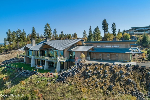 view of front facade with a standing seam roof, metal roof, and a chimney