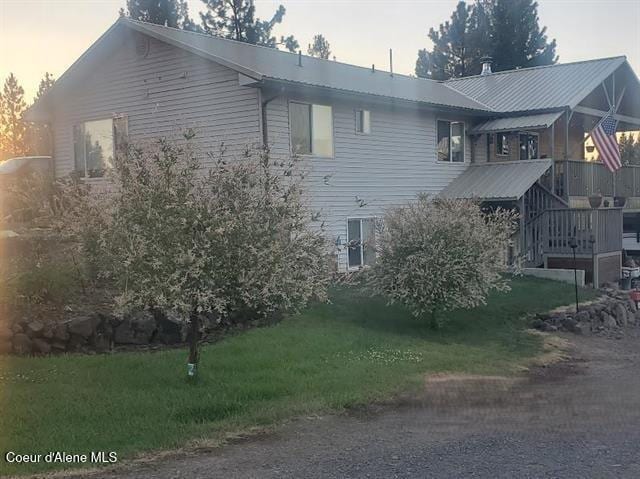 property exterior at dusk featuring a yard