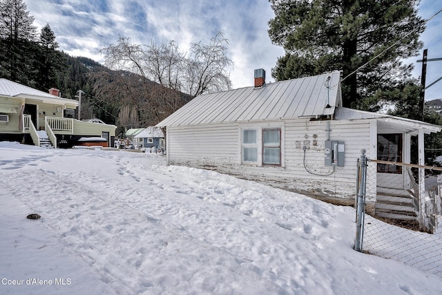 315 Montana St, Mullan, ID 83846 - view of snow covered exterior featuring a standing seam roof, a chimney, and metal roof