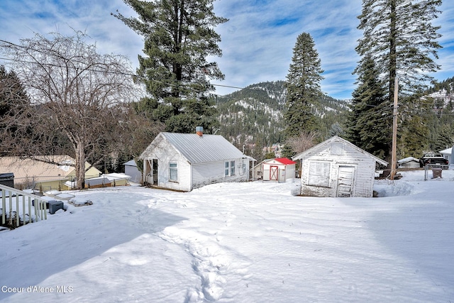 315 Montana St, Mullan, ID 83846 - yard covered in snow with an outbuilding, a shed, and fence