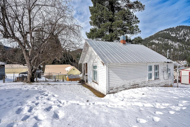 315 Montana St, Mullan, ID 83846 - view of snow covered exterior featuring metal roof and fence