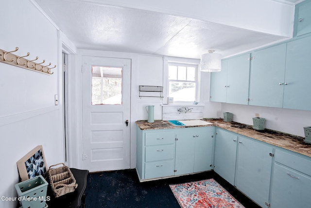 315 Montana St, Mullan, ID 83846 - kitchen with blue cabinets, a textured ceiling, and a sink