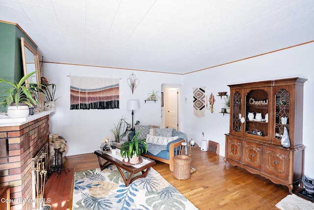 315 Montana St, Mullan, ID 83846 - living room featuring baseboards, a brick fireplace, wood finished floors, and crown molding