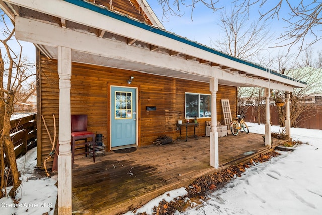 snow covered property entrance with fence