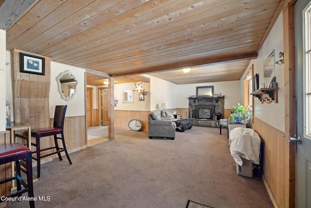 living room with wooden ceiling, wainscoting, and wooden walls