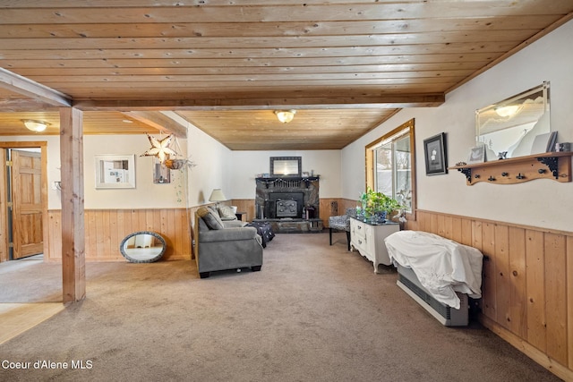 living room with carpet floors, a wainscoted wall, wooden walls, wooden ceiling, and beamed ceiling