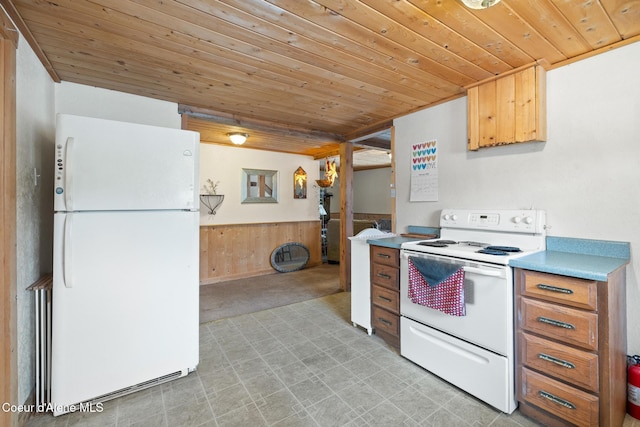 kitchen featuring wooden ceiling, a wainscoted wall, white appliances, wood walls, and light countertops