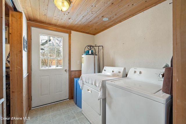 washroom featuring laundry area, wainscoting, wooden ceiling, washing machine and dryer, and water heater