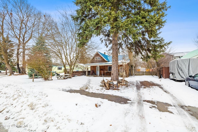 view of front of property featuring a garage, covered porch, and fence