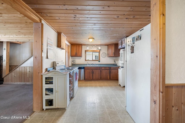 kitchen with white appliances, brown cabinetry, wooden ceiling, and wood walls