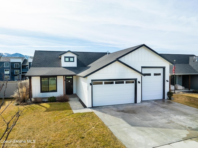 modern farmhouse with a garage, concrete driveway, fence, a front lawn, and board and batten siding