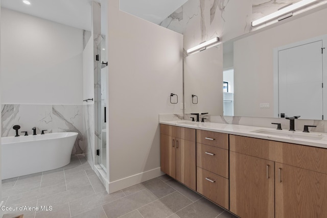 full bath featuring a sink, tile walls, a shower stall, and double vanity