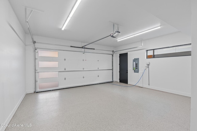 garage featuring baseboards, electric panel, and a garage door opener