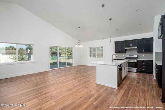 1133 W Cordgrass Ave, Post Falls, ID 83854 - kitchen with an island with sink, open floor plan, stainless steel appliances, light countertops, and under cabinet range hood