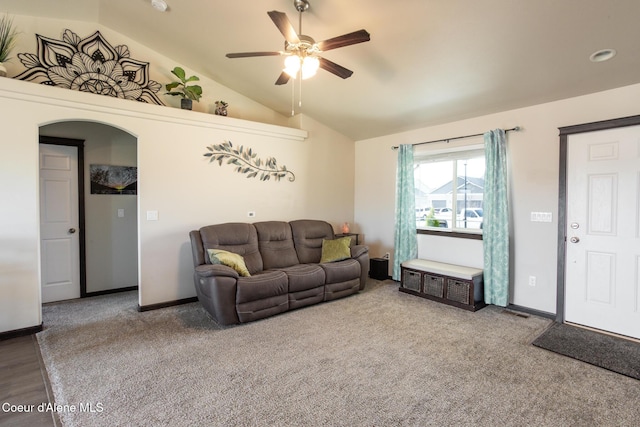 living area with lofted ceiling, carpet floors, baseboards, and arched walkways