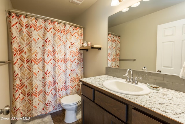 bathroom with visible vents, decorative backsplash, a shower with shower curtain, toilet, and vanity