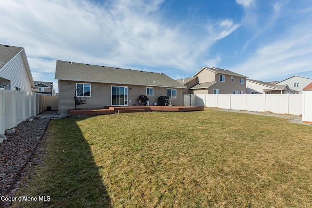 back of house with a fenced backyard, a lawn, and a wooden deck