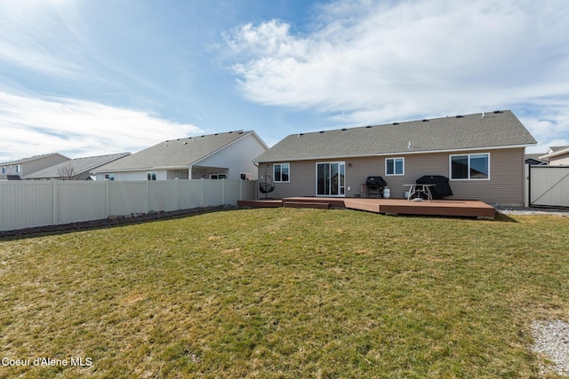 rear view of house with a deck, a yard, a fenced backyard, and a gate