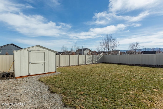 view of yard featuring a fenced backyard, a storage unit, and an outdoor structure