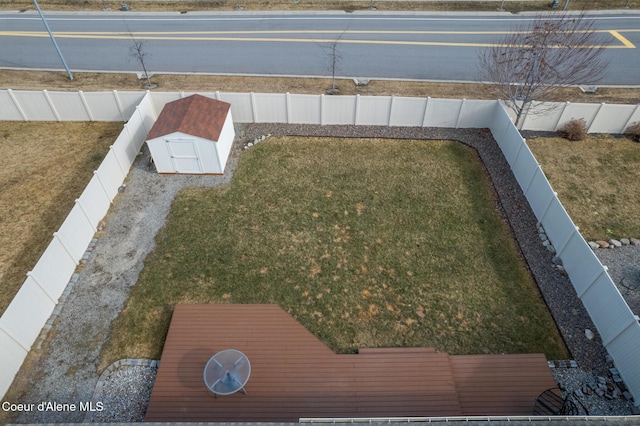 view of yard with a fenced backyard, a storage unit, and an outdoor structure