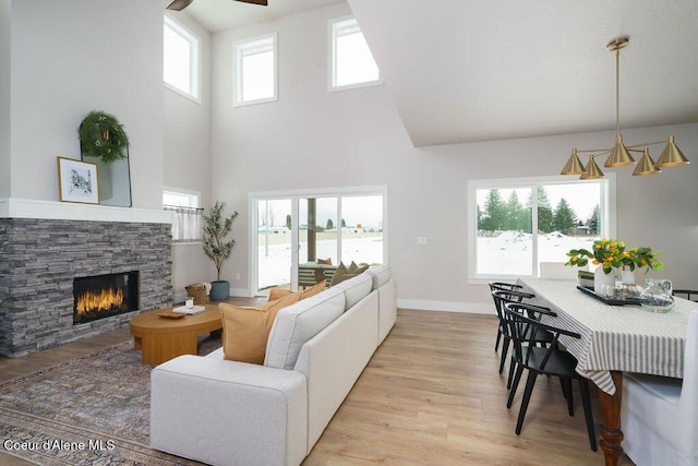 living room featuring light wood-style floors, a fireplace, and baseboards