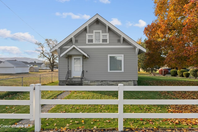 bungalow-style house featuring entry steps and a fenced front yard