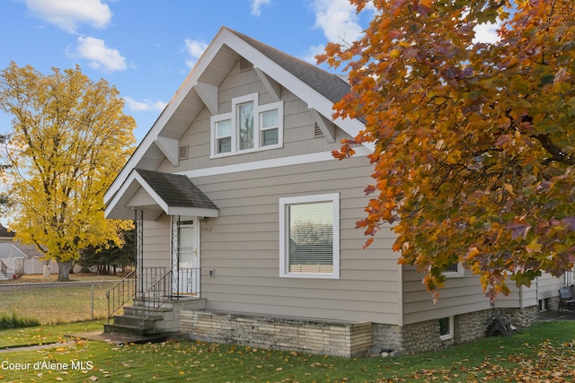 view of front of home with a front yard and fence