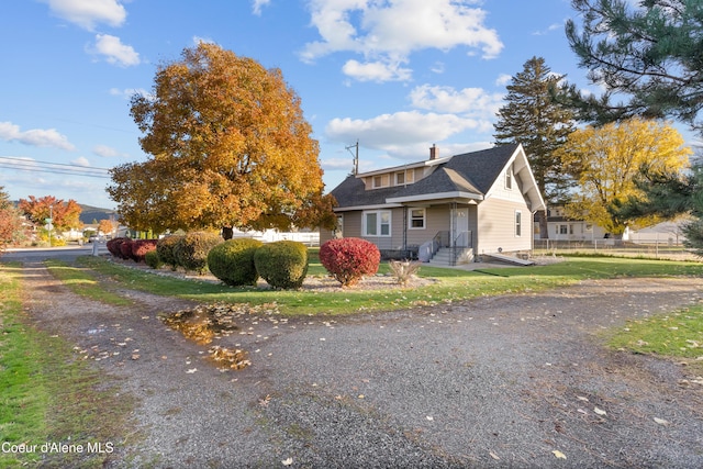 view of front of house with a shingled roof, fence, and a chimney