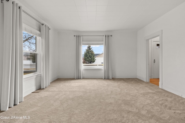 carpeted empty room featuring baseboards