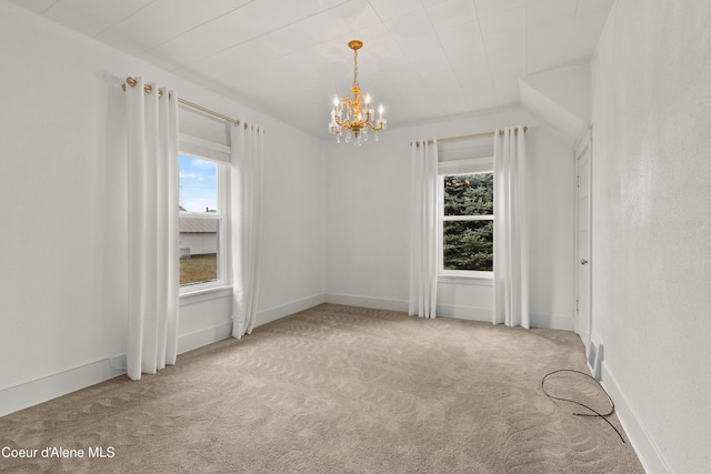 empty room with baseboards, a notable chandelier, and carpet