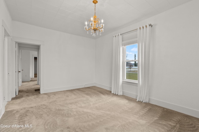 unfurnished room featuring baseboards, carpet, and an inviting chandelier