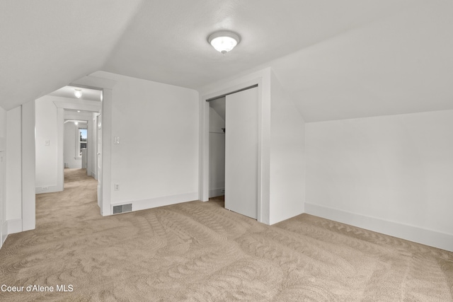 bonus room with visible vents, lofted ceiling, baseboards, and carpet flooring