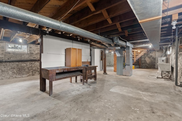 basement featuring stairs and heating unit