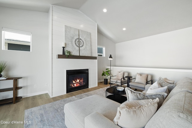 living room with recessed lighting, a fireplace, wood finished floors, baseboards, and vaulted ceiling