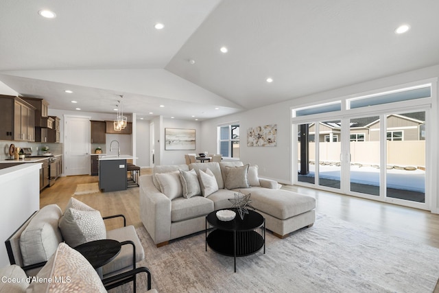 living area featuring light wood-type flooring, vaulted ceiling, and recessed lighting