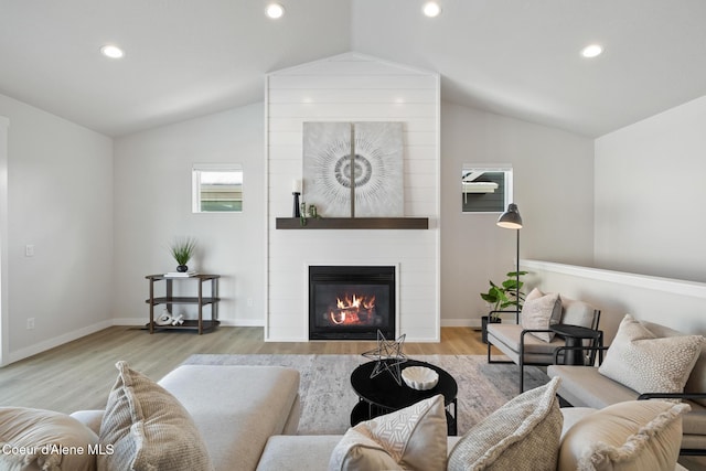 living room featuring baseboards, lofted ceiling, wood finished floors, a fireplace, and recessed lighting