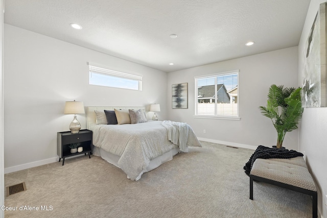 bedroom with light carpet, recessed lighting, visible vents, and baseboards