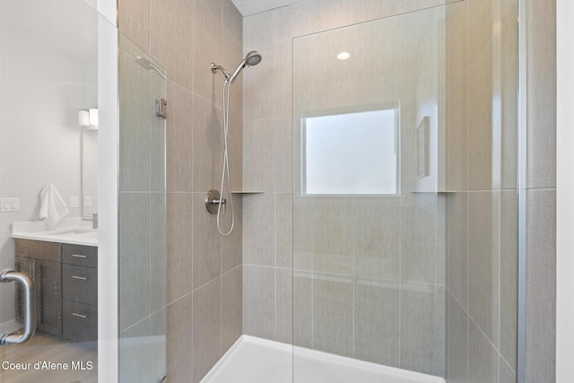 bathroom with a shower stall and vanity